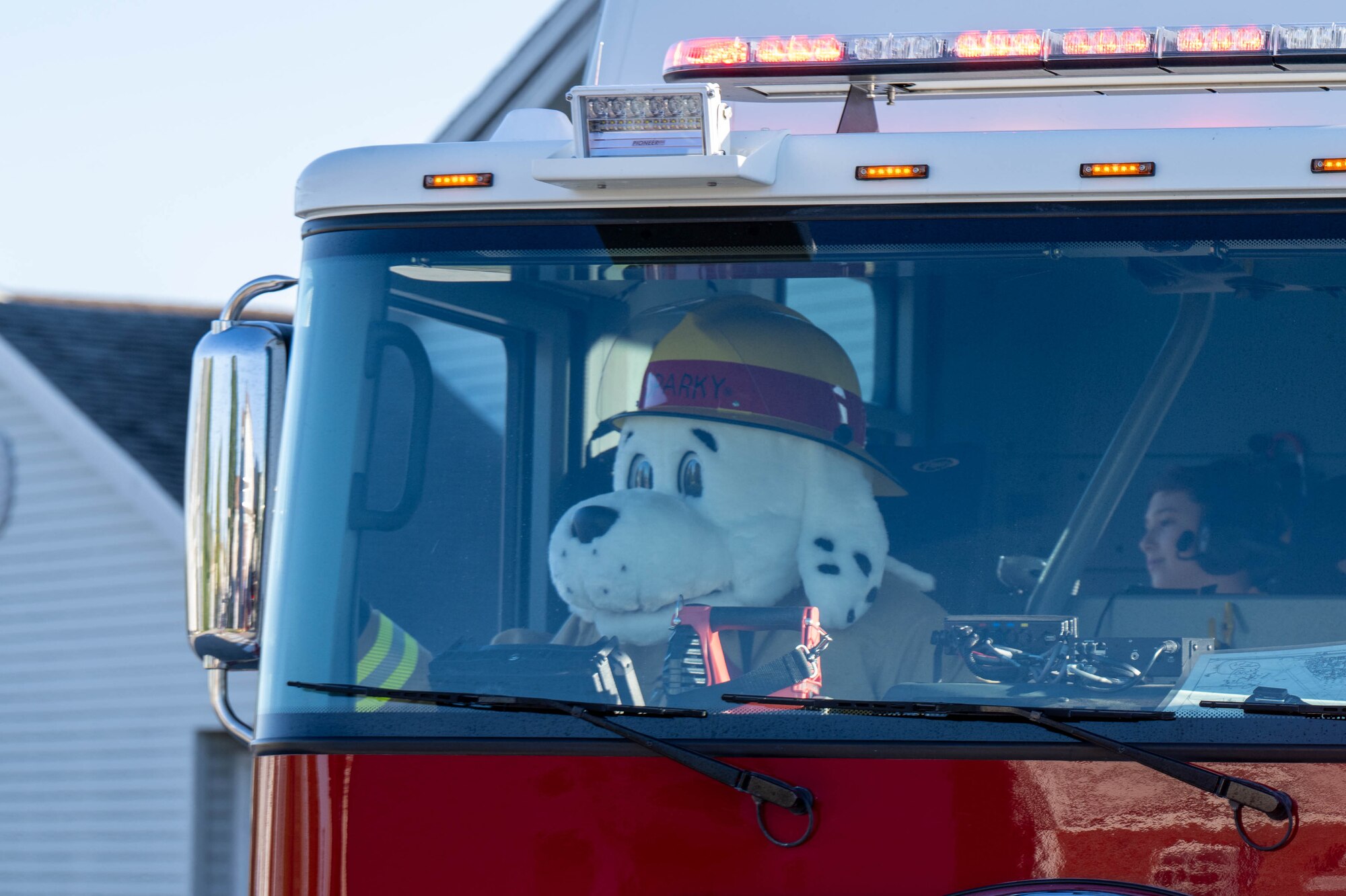 Sparky, the Fire Prevention Week mascot, waves to spectators during the 2024 Fire Prevention Week Parade at Dover Air Force Base, Delaware, Oct. 11, 2024. During Fire Prevention Week, the Dover AFB Fire Department hosted various activities to raise fire safety awareness for Airmen and their families. (U.S. Air Force photo by Mauricio Campino)