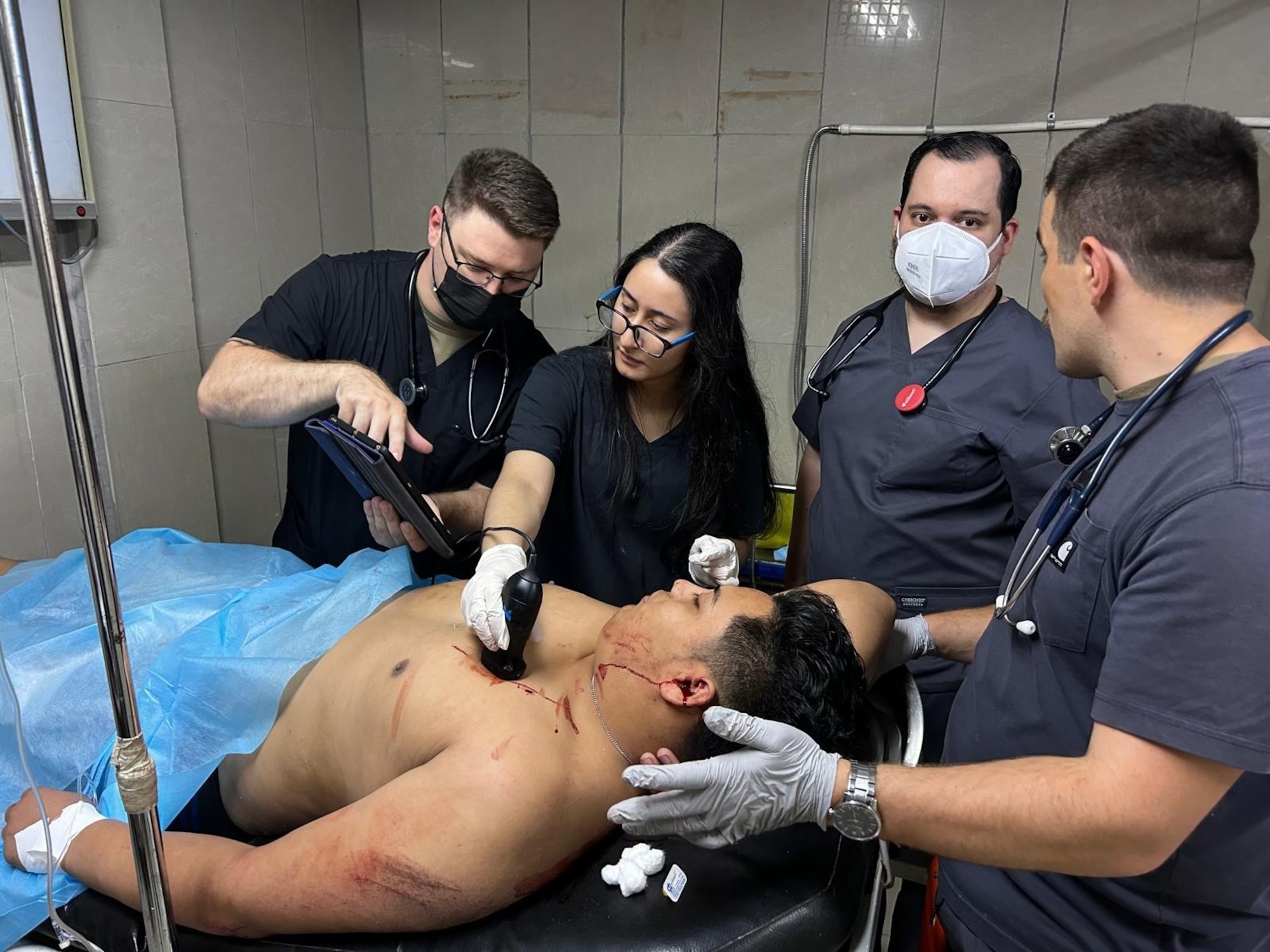 Doctors treat patient in hospital room