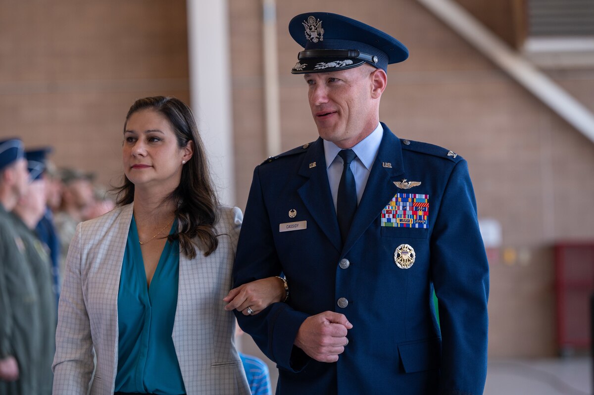 A man in a military dress uniform walks with his wife.