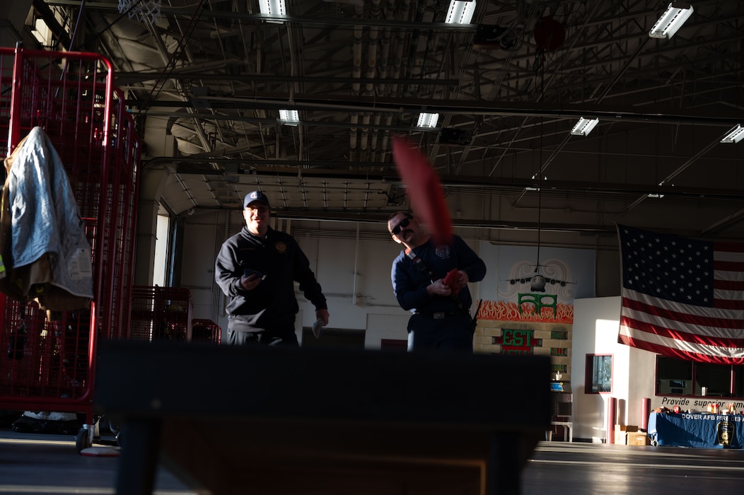 Firefighters assigned to the 436th Civil Engineer Squadron Fire Department, play corn hole during an open house at Dover Air Force Base, Delaware, Oct. 10, 2024. The open house took place during Fire Prevention Week, a nationally observed week used to educate people on fire prevention. (U.S. Air Force Photo by Dieondiere Jefferies)