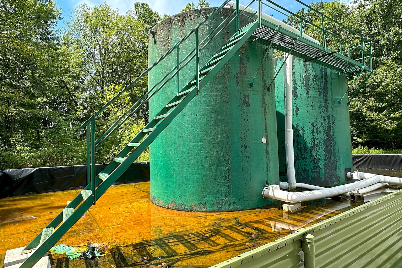 Two large above-ground wells stand in a shallow pool. Stairs lead to the tops of the towers.