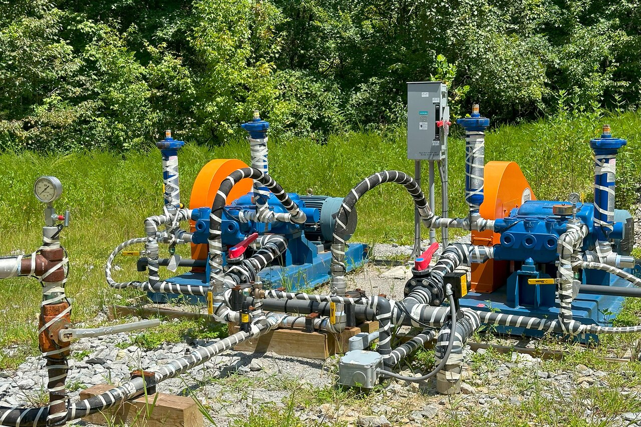 Several pipes are attached to a system on the ground.