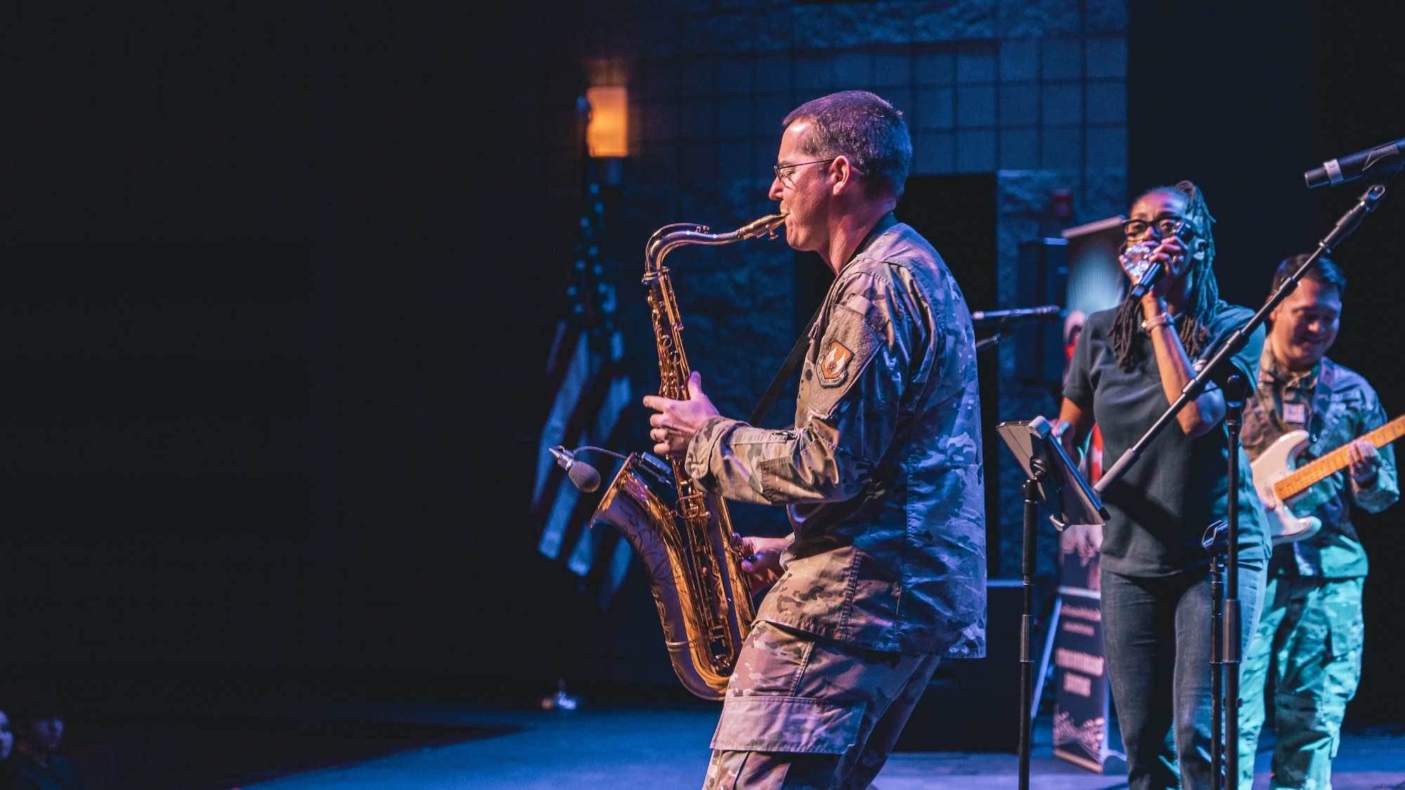 Greg Pflugh plays saxophone at a high school audience.