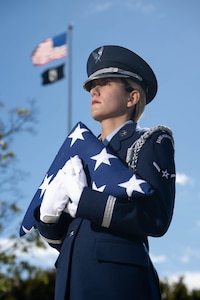 U.S. Air Force Airman 1st Class Massiel Perez, 436th Force Support Squadron services journeyman, holds a folded American flag at Dover Air Force Base, Delaware, Oct. 15, 2024. Perez was born and raised in Cuba and immigrated to the U.S. four years ago. She became a naturalized U.S. citizen shortly after joining the Air Force. She is currently serving with the Dover AFB Honor Guard. (U.S. Air Force photo by Mauricio Campino)