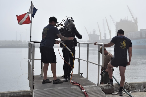 Diver walks on platform after emerging from water