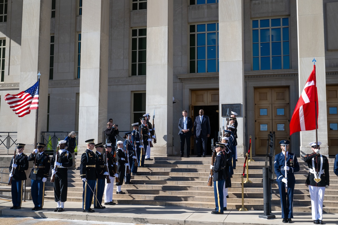 Two men stand on the steps of the Pentagon during a ceremony.
