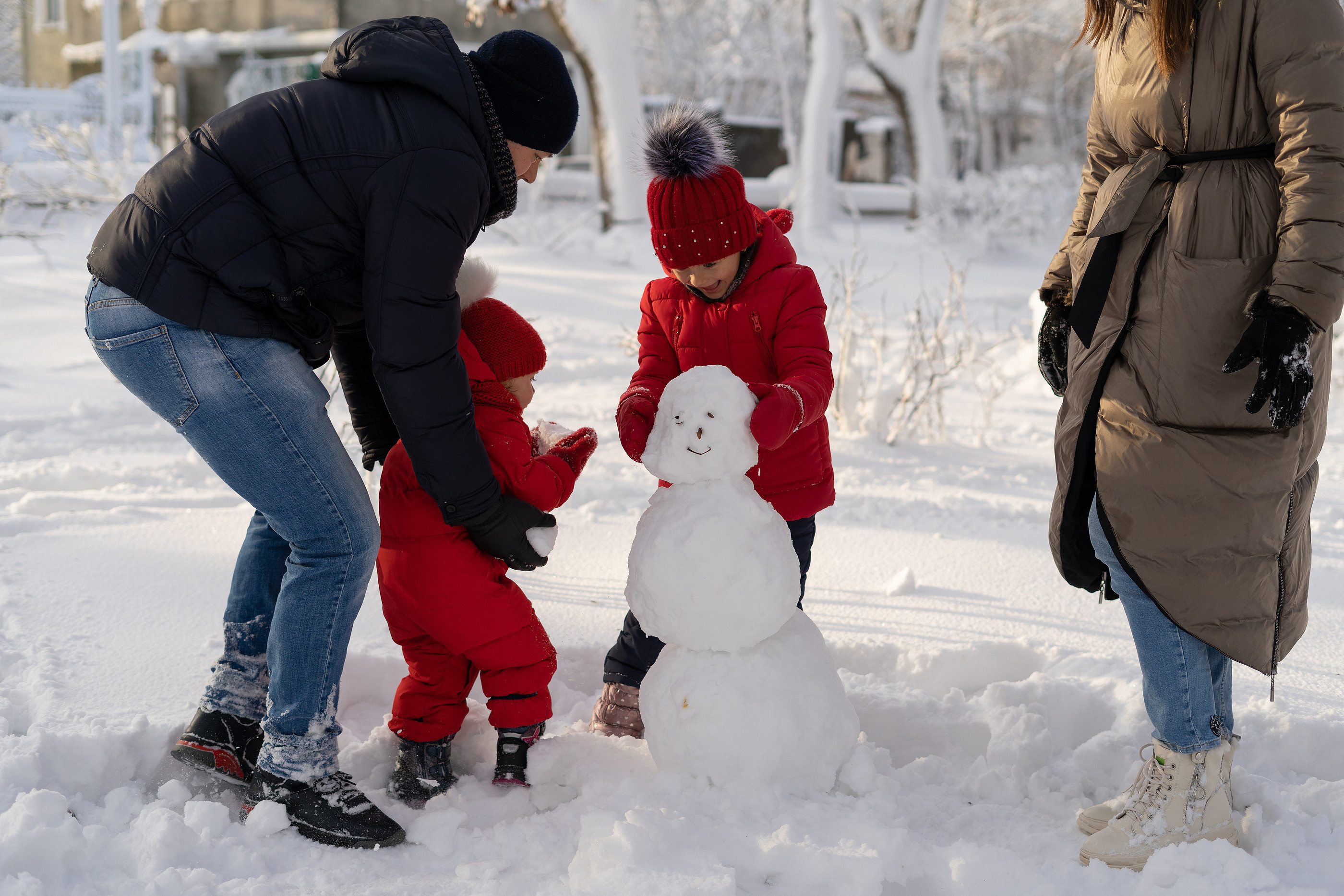 Happy Family With Two Little Girls In A Winter Park On A Sunny Day