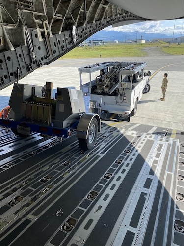 Airman backing up a truck onto a C-17 for loading