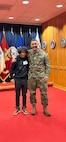 U.S. Army 1st Lt. Andrew Devine, right, stands for a photograph with his son, Isaiah Castellanos, following Castellanos' oath of enlistment at the Military Entrance Processing Station-Baltimore, at Fort Meade, Md., in January 2023. 1st Lt. Devine served on active duty from 2004 to 2010, and joined the D.C. National Guard in 2020. His son joined the organization three years later.