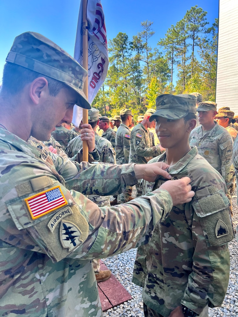 U.S. Army 1st Lt. Andrew Devine, left, pins Air Assault wings on his son, U.S. Army Pfc. Isaiah Castellanos, during a graduation ceremony at Fort Moore, Ga., on Sept. 20, 2024. Upon completion of Air Assault School each soldier is able to perform skills required to make maximum use of helicopter assets in training and in combat to support mission objectives.