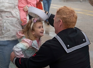 ET2 David Gaddis greets his family at Naval Station Rota, Spain during a homeport switch for USS Oscar Austin (DDG 79) from Naval Station Norfolk.