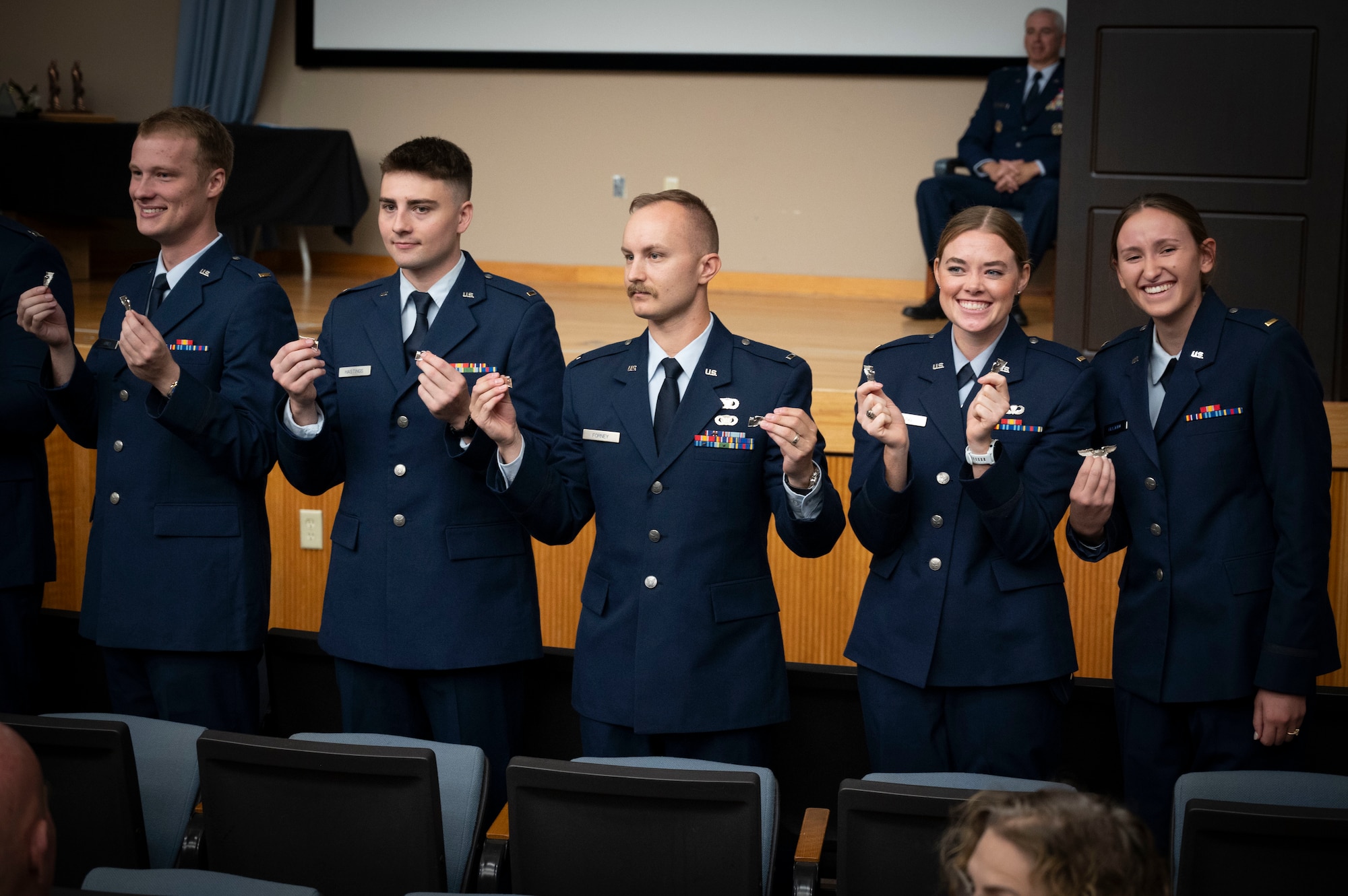 U.S. Air Force pilots from Class 25-01 hold up their broken wings during their Undergraduate Pilot Training (UPT) graduation ceremony at Laughlin Air Force Base, Texas, Oct. 11, 2024. According to tradition, the first pair of wings should never be worn but broken in two, with one half kept by the pilot and the other given to a significant person, to ensure good fortune in the novice pilot's aviation career. (U.S. Air Force photo by Senior Airman Kailee Reynolds)