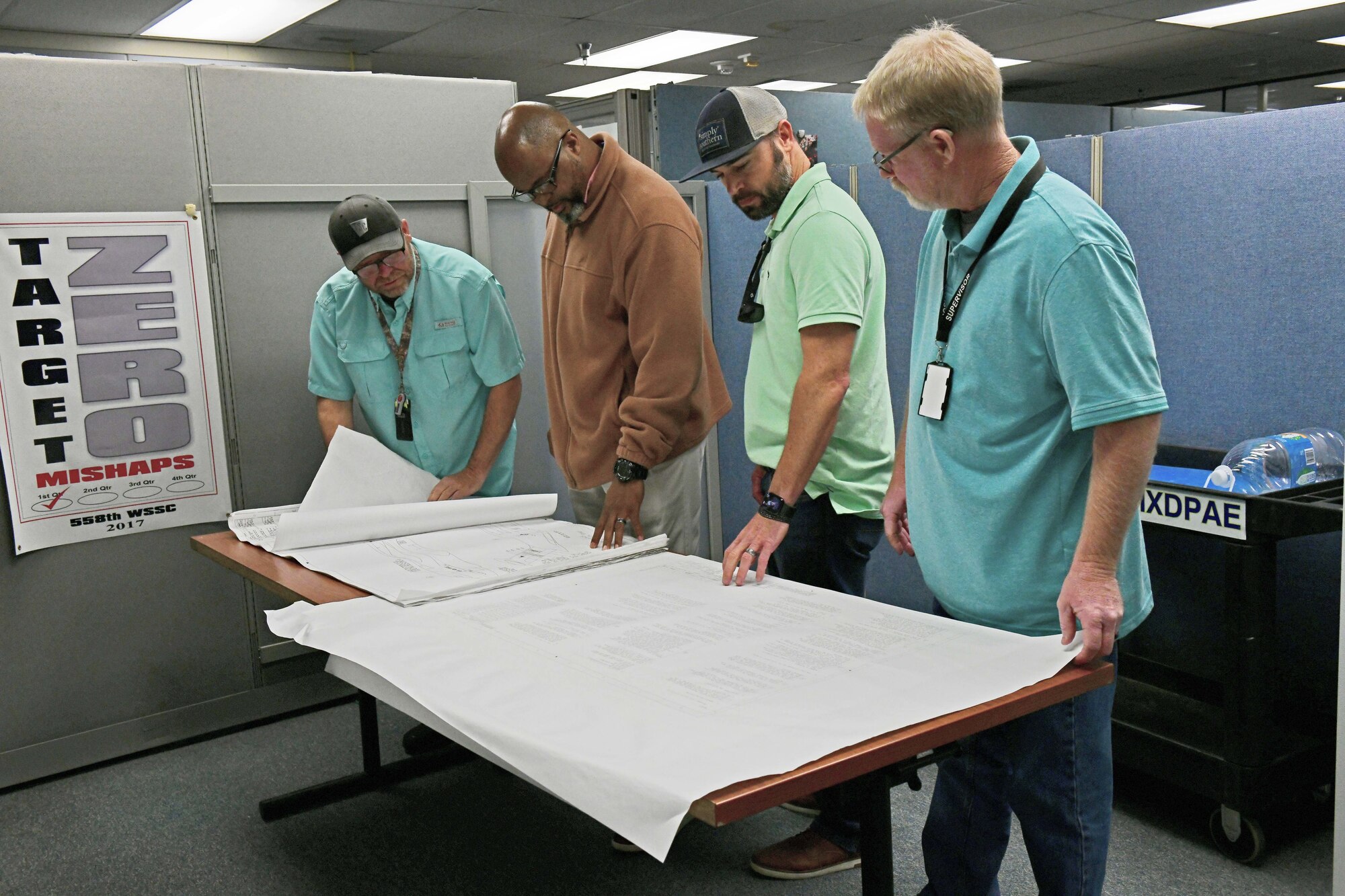 A group of people standing and looking at documents
