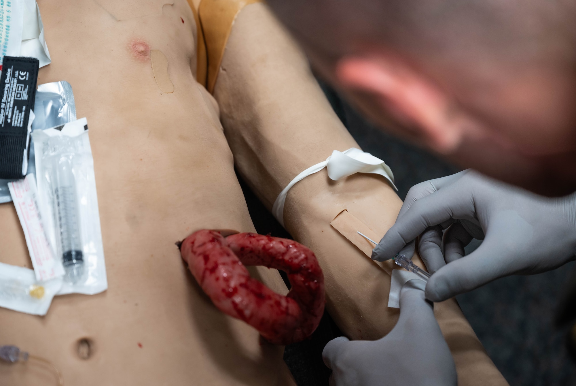 A German SWAT member inserts a needle catheter into a simulated patient while receiving Tactical Combat Casualty Care training at Ramstein Air Base, Germany, Oct. 8, 2024. Throughout the week, 16 German SWAT members were trained on how to treat massive bleeding by using equipment such as simulated patient mannequins. (U.S. Air Force Photo by Senior Airman Jared Lovett)