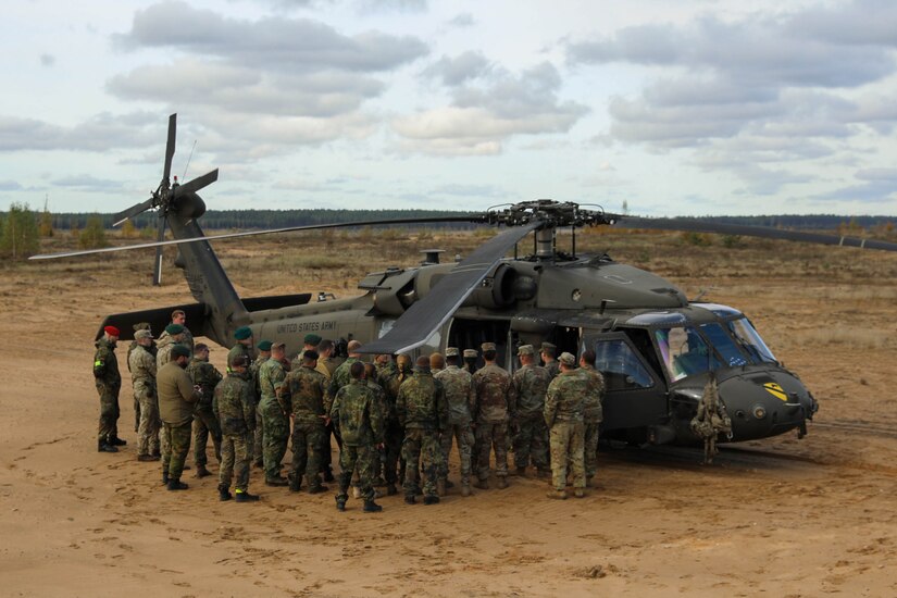 U.S. Army crew members assigned to Alpha Company, 2nd Battalion, 227th Aviation Regiment, 1st Air Cavalry Brigade, 1st Cavalry Division, explain the different sections of a UH-60 Black Hawk to soldiers from several NATO countries before taking them on a flight during Operation Iron Wolf at Camp Herkus, Lithuania, Oct.13, 2024. Operation Iron Wolf was a NATO Multinational Battlegroup exercise led by the Lithuanian army. The 1st Cavalry Division’s mission is to engage in multinational training and exercises across the continent, strengthening interoperability with NATO allies and regional security partners, which provides competent and ready forces to V Corps, America’s forward-deployed corps in Europe. (U.S. Army photo by Staff Sgt. Richard Wooten)