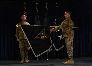 U.S. Space Force Colonel Andrew Menschner, Mission Delta 31 commander and Chief Master Sgt. Joshua Griffin, MD 31 senior enlisted leader, unfurl the ceremonial guidon during a redesignation ceremony at Peterson Space Force Base, Colo., Oct. 15, 2024. During the ceremony the Position, Navigation and Timing (PNT) Provisional Delta was officially redesignated as Mission Delta 31. The new MD 31 flag includes components such as the Polaris star and southern cross, which represent centuries of humanity looking to the stars for navigation, as well as its critical role in driving the course of progress, then, now and in the future.(U.S. Space Force photo by John Ayre)