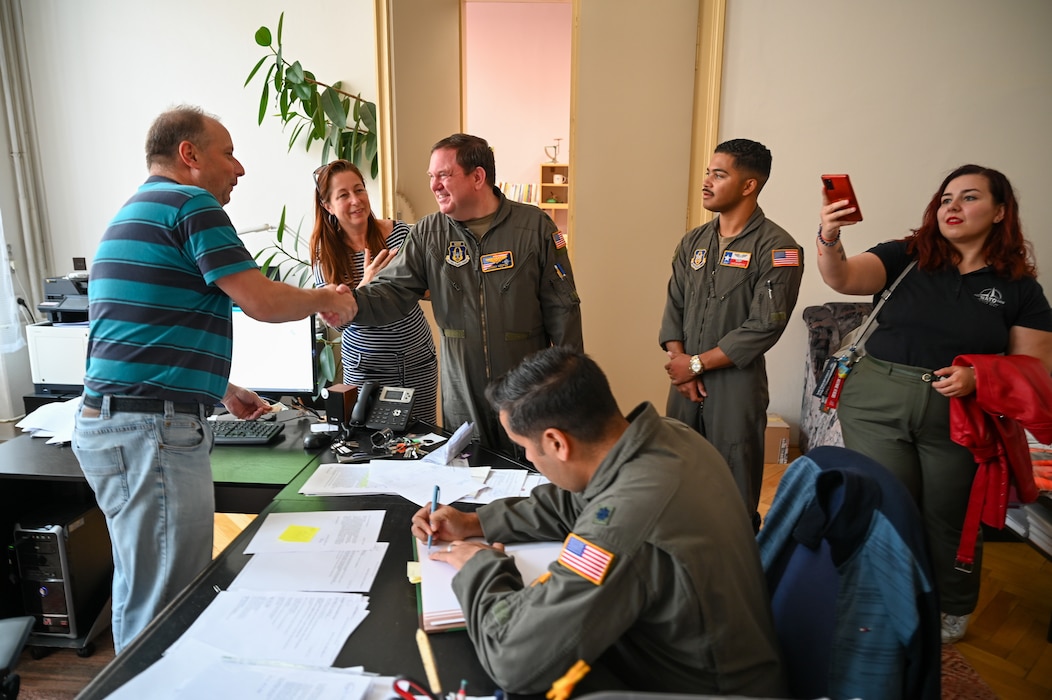 Lt. Col. Jeremy Hooper, left, 68th Airlift Squadron evaluator C-5 pilot, Lt. Col. Brian Biggerstaff, center, 68th AS C-5 pilot, and Staff Sergeant Jaylen Myles, right, 68th C-5 flight engineer instructor, meet Pavel Kerekeš, headmaster of Masarykovo gymnázium Příbor, Sept. 24, 2024.