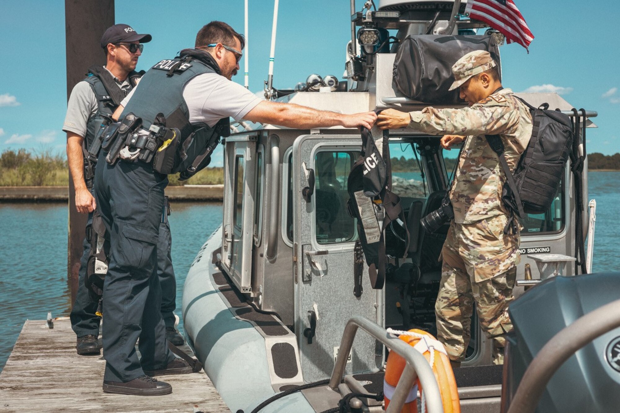 A police assist an airmen out of a boat.