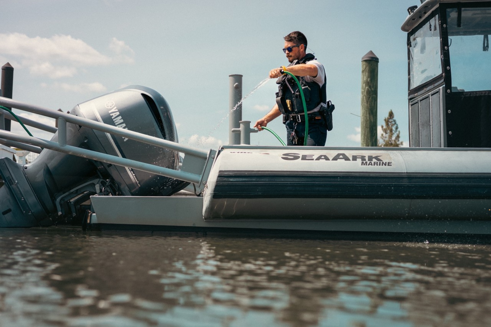 A man sprays down a motor on a boat.