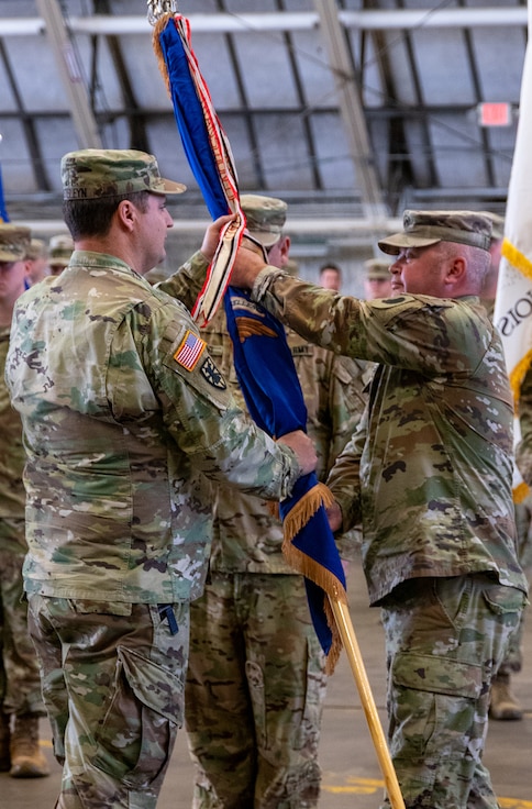 Lt. Col. Jason Celletti, of Springfield, passes the 1st Battalion, 106th Aviation Regiment’s flag, to Col. Max Casteleyn, commander of the 65th Troop Command, signifying his relinquishment of command during the battalion’s change of command ceremony Oct. 5 in Peoria.