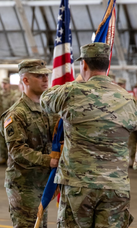 Col. Max Casteleyn, commander of the 65th Troop Command, passes the 1st Battalion, 106th Aviation Regiment’s flag to Lt. Col. Zachary DeGroot, of Chatham, signifying his assumption of command during the battalion’s change of command ceremony Oct. 5 in Peoria.