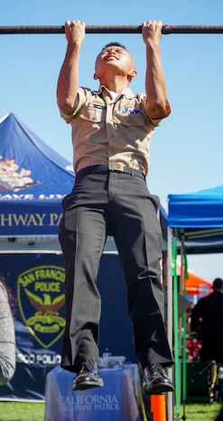 An expo attendee participates in a Marine Corps pull-up challenge at the EXPO on the Marina Green during San Francisco Fleet Week 2024 in San Francisco, Oct. 11, 2024. SFFW, now in its 43rd iteration, is a time-honored sea service celebration that allows citizens of the Bay Area to witness today’s maritime capabilities firsthand. Nearly 2,500 Sailors, Marines, and Coast Guardsmen will showcase their capabilities and equipment, participate in various community service events, and enjoy the hospitality of the Bay Area during the event. (U.S. Marine Corps photo by Lance Cpl. Avery Wayland)