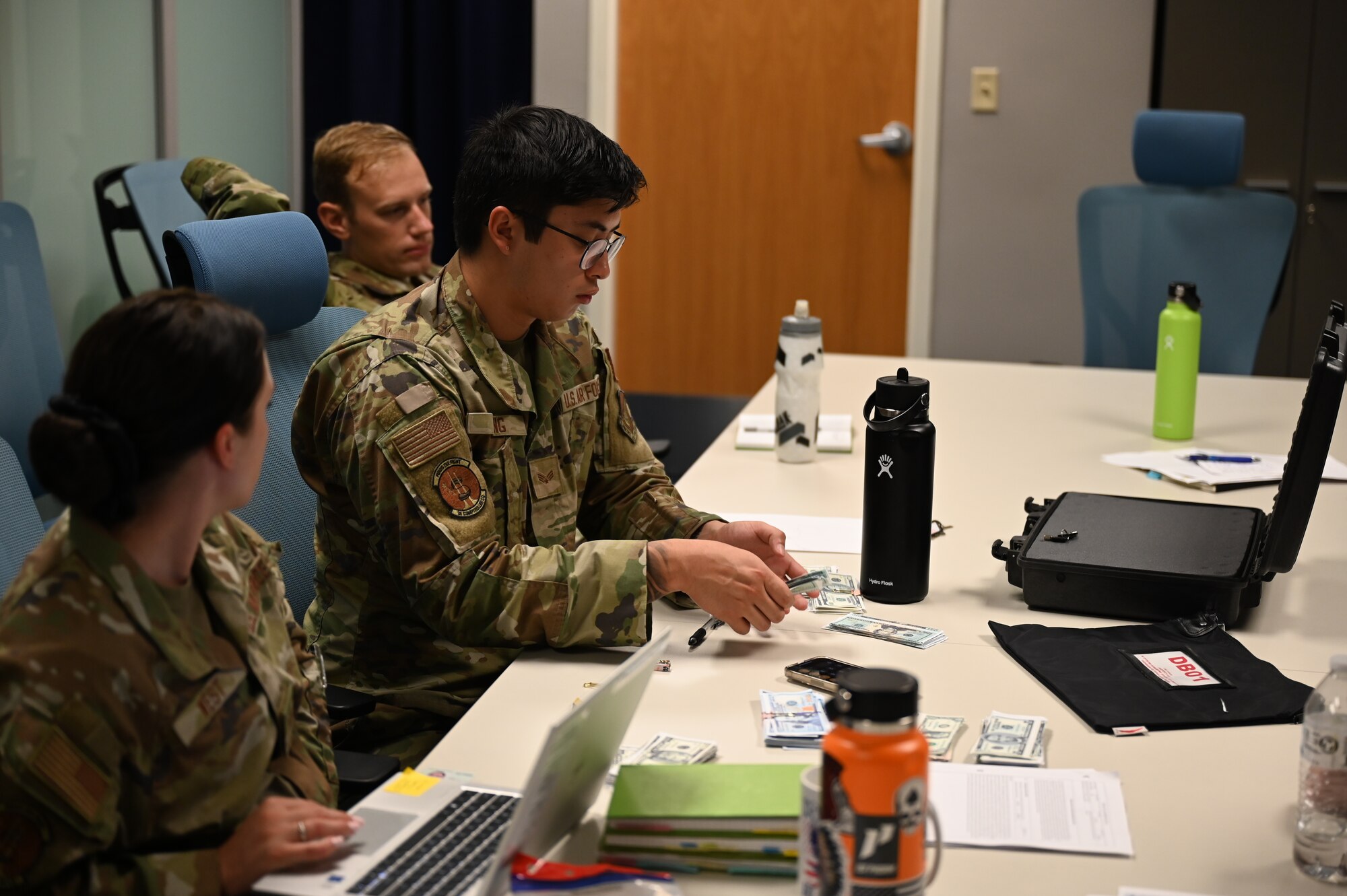 Senior Airman Jason King, 36th Comptroller Squadron financial analyst, handles money as part of Slingstone 24-4 at Andersen Air Force Base, Guam, October 15, 2024. The 36th Comptroller Squadron demonstrated their abilities in the training exercise to become more operationally effective. (U.S. Air Force photo by Airman 1st Class Adasha Williams)
