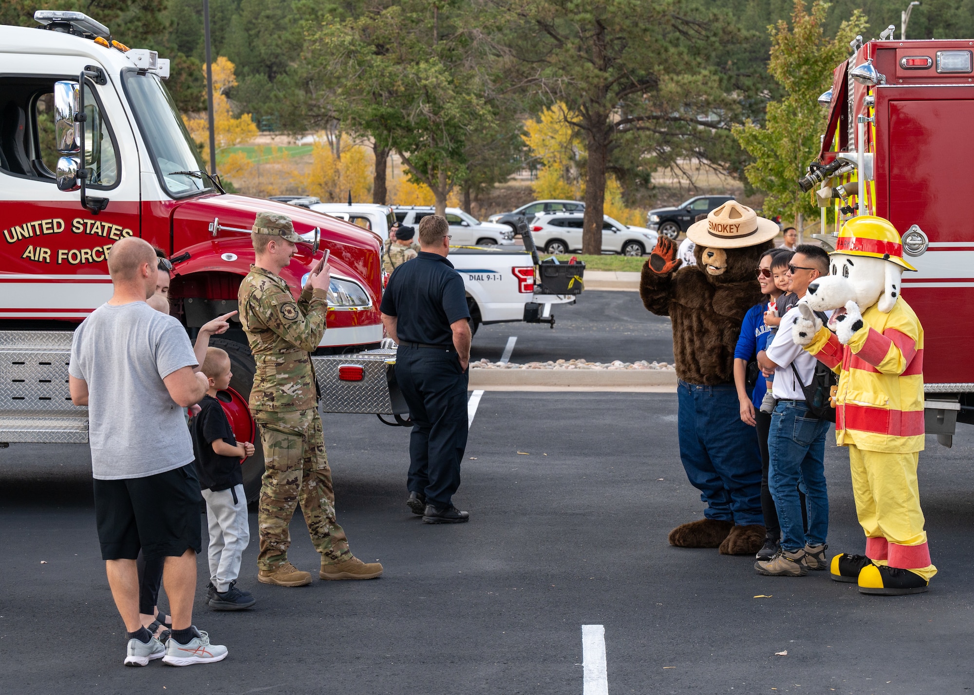 A family takes a photo with Smokey the Bear and Sparky the Fire Dog mascots during a Fire Prevention Week meet-and-greet at the U.S. Air Force Academy, Colorado on October 11th 2024.