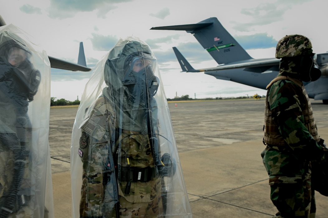 U.S. Air Force Capt. Kaitlin Winter, 7th Expeditionary Airlift Squadron pilot, and Senior Airman Katheryn Hamilton, 7th EAS loadmaster, wait to be decontaminated after exiting a C-17 Globemaster III from Joint Base Lewis-McChord, Washington, during Exercise Rainier War 25A, at Kalaeloa, Hawaii, Oct. 11, 2024.