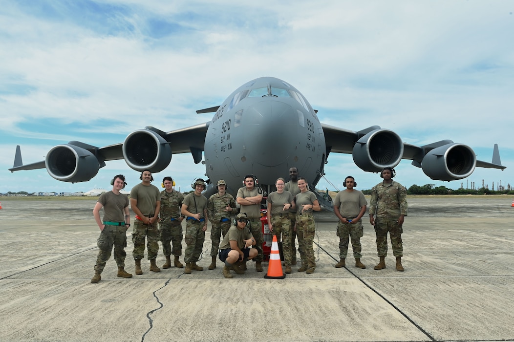 Airmen from the 7th Expeditionary Airlift Squadron stand in front of a C-17 Globemaster III from Joint Base Lewis-McChord, Washington, before a flight at Kalaeloa, Hawaii, Oct. 11, 2024.