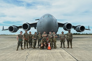 Airmen from the 7th Expeditionary Airlift Squadron stand in front of a C-17 Globemaster III from Joint Base Lewis-McChord, Washington, before a flight at Kalaeloa, Hawaii, Oct. 11, 2024.