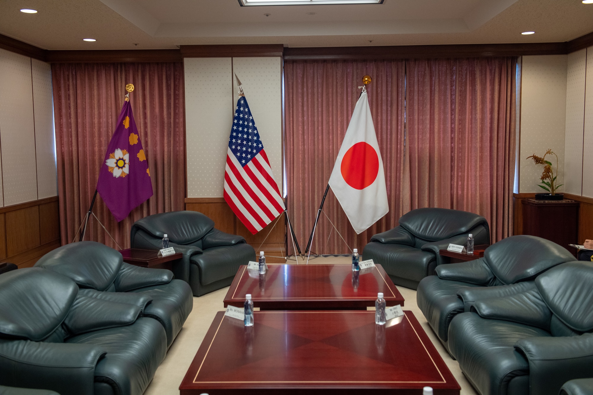 A meeting room with the U.S. and Japan flags is displayed