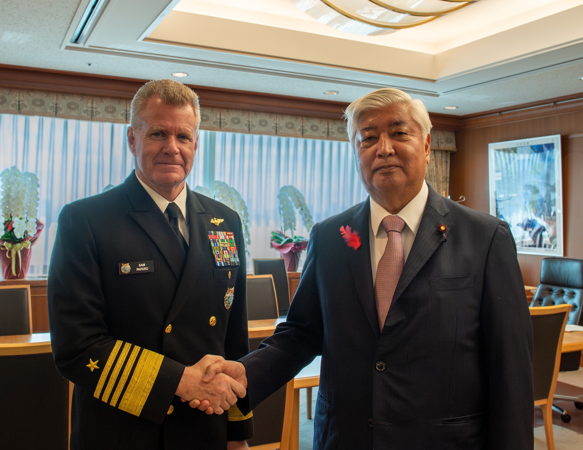 INDOPACOM commander shakes hands with the Foreign Minister of Japan in a meeting room.