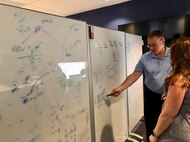 civilians work at whiteboards