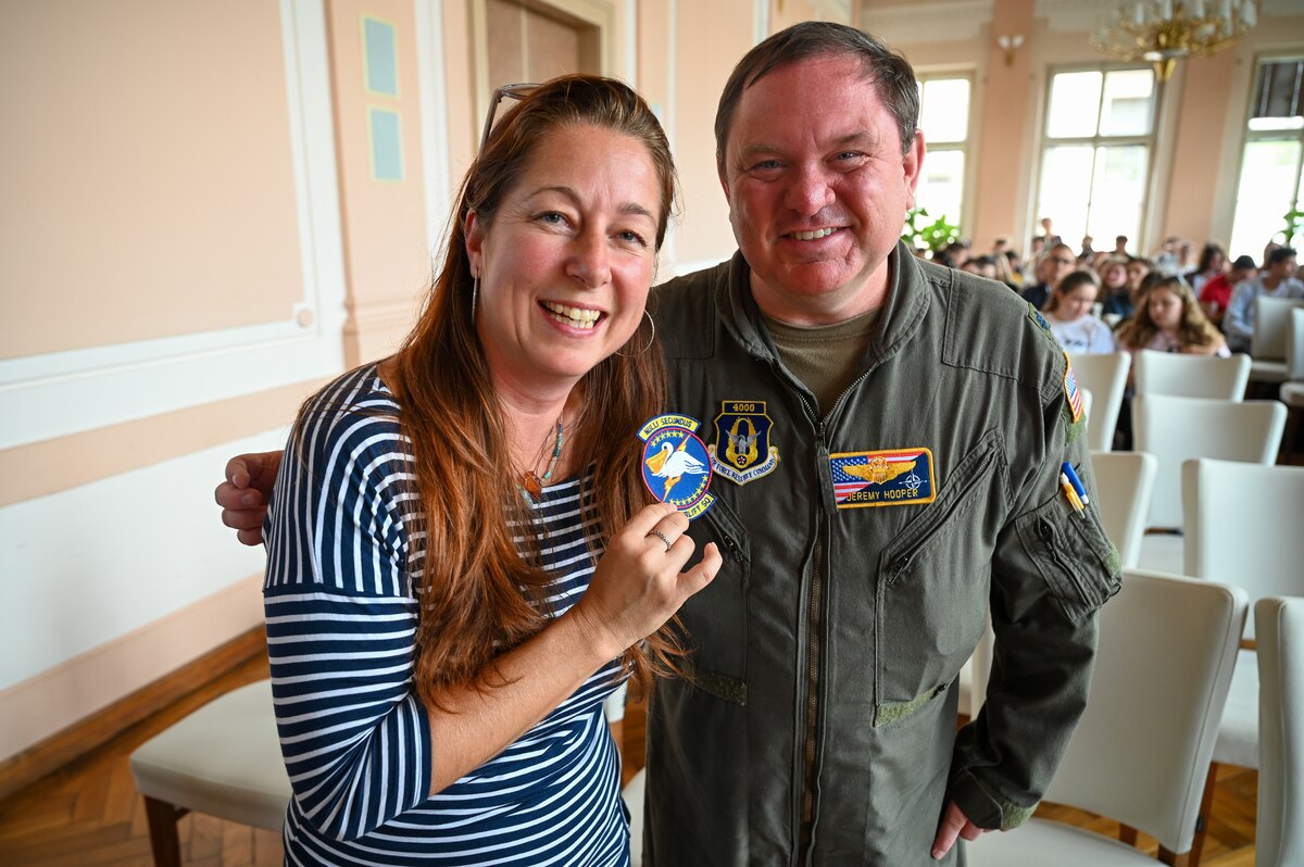 Lt. Col. Jeremy Hooper, 68th Airlift Squadron C-5 pilot evaluator, gifts a 68th AS unit patch to Marie Stuchla, magister of language, at Masarykovo gymnázium Příbor, a high School in the Czech Republic, Sept. 24, 2024.