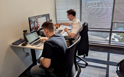 military members in civilian clothes work on computers