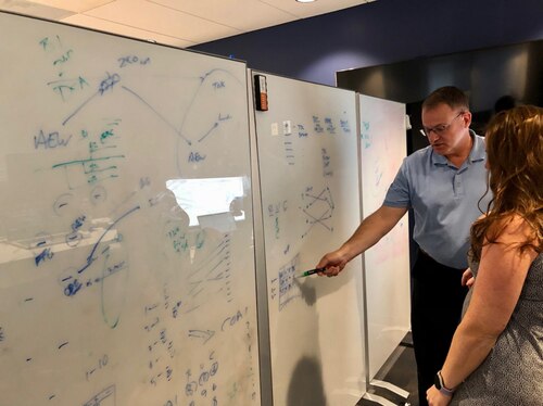 civilians work at whiteboards