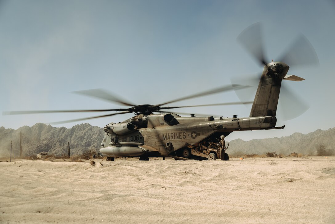 U.S. Marines assigned to 3rd Low Altitude Air Defense Battalion, 3rd Marine Aircraft Wing and Marine Aviation Weapons and Tactics Squadron One, load a Light Marine Air Defense Integrated System into a CH-53E Super Stallion aircraft during a ground-based air defense exercise as part of Weapons and Tactics Instructor course 1-25 at Tacts Airfield near Wellton, Arizona, Oct. 10, 2024. WTI is a seven-week training event hosted by MAWTS-1 which emphasizes operational integration of the six functions of Marine aviation in support of the Marine Air Ground Task Force, Joint and Coalition Forces. (U.S. Marine Corps photo by Lance Cpl. Micah Thompson)