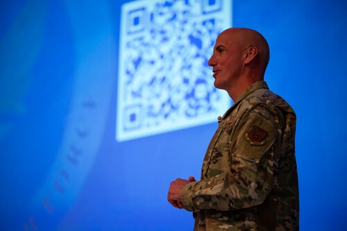 A military member speaks on stage.