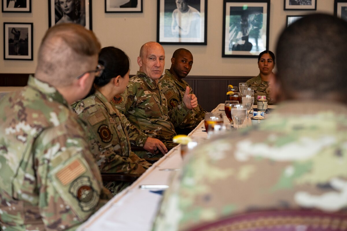 A military member speaks to a group of Airmen.