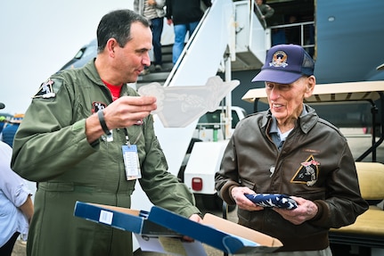 Jim Kunkle, World War II U.S. Army Air Corps veteran, receives the 401st Fighter Squadron patch from Col. Andrew Malousek, 155th Air Refueling Wing vice wing commander, Sept. 21, 2024, during the Central Coast AirFest at the Santa Maria Airport in Santa Maria, California. Kunkle served as a fighter pilot during WWII and flew P-38 and P-57 aircraft.