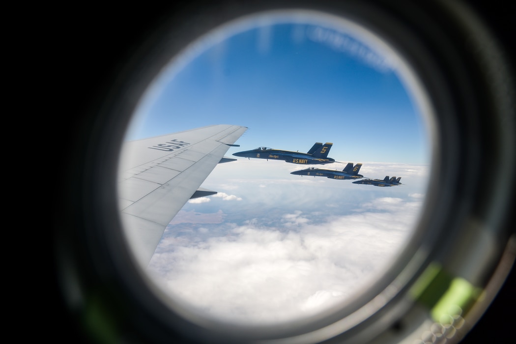 Four U.S. Navy Blue Angels F/A-18 Super Hornet aircraft fly next to a KC-46 Pegasus aircraft in the skies of Texoma, Oct. 14, 2024. The Blue Angels fly closer to the KC-46 when the aircraft approaches turbulence to create a more aerodynamic formation. (U.S. Air Force photo by Airman 1st Class Lauren Torres)