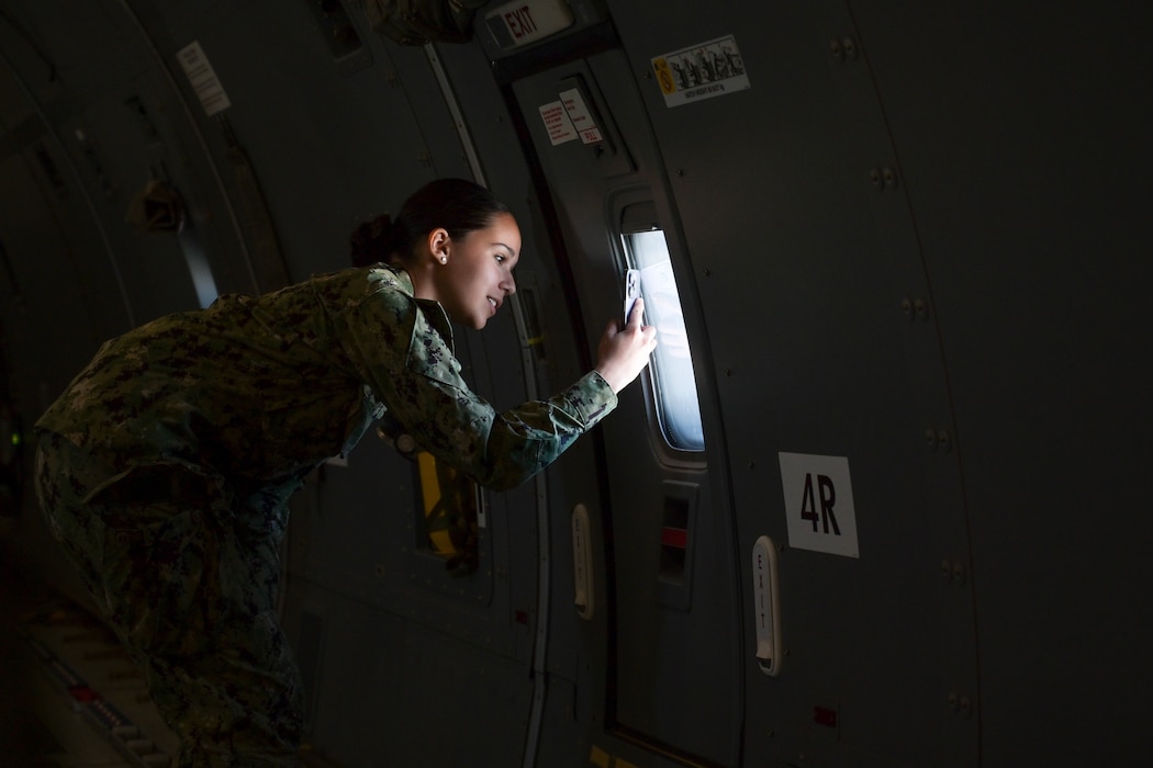 Luisa Leao, The University of Oklahoma Naval ROTC midshipman, takes a photo through the window of a KC-46 Pegasus aircraft in the skies of Oklahoma, Oct. 14, 2024. Leao has joined the Naval ROTC with aspirations of becoming an astronaut. (U.S. Air Force photo by Airman 1st Class Lauren Torres)