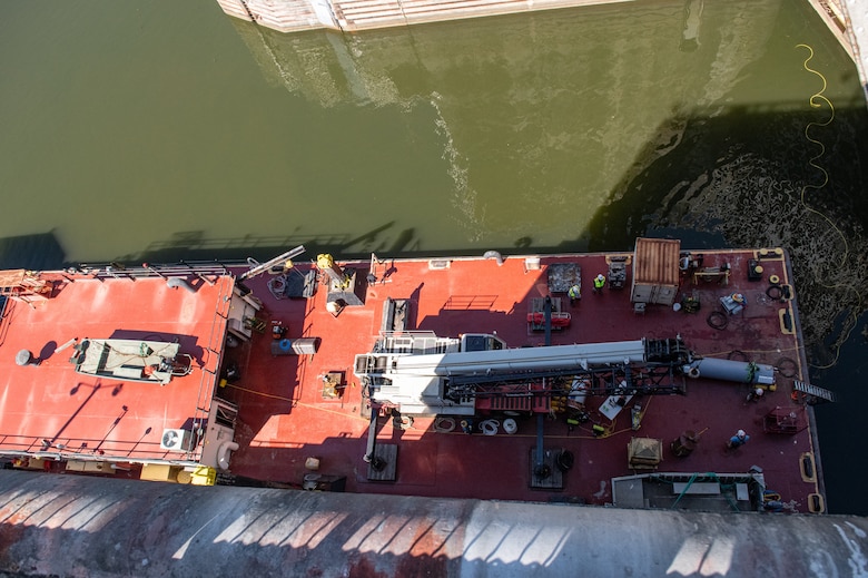 An aerial view of the ND-40, a maintenance barge belonging to the U.S. Army Corps of Engineers Nashville District, from the top of the main chamber at Wilson Lock in Florence, Ala., Oct. 9, 2024. The barge serves as a base of operations for dive-certified district lock mechanics as well as operators of a Remotely-Operated Vehicle (ROV) visiting from the USACE Engineer Research and Development Center (ERDC). The power cable connecting the ROV to the barge is visible in the upper-right corner of the photo.