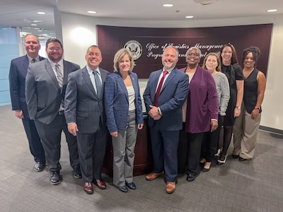 The Defense Logistics Agency’s Deputy Director of Logistics Operations Kristin French, left center, and the Deputy Assistant Secretary of State for Logistics Management Seth Green, right center, pose with members of their staff after the signing of a ten-year, $600 million interagency agreement Oct. 7, 2024,