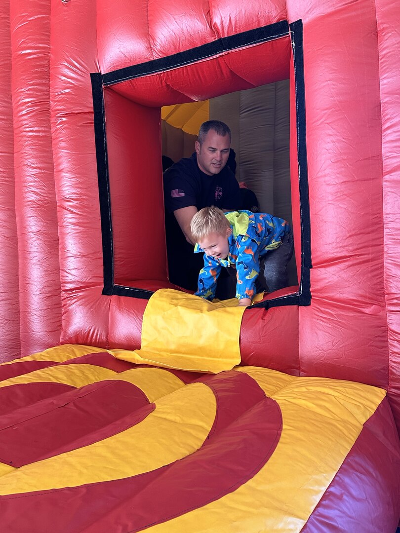 A firefighter shows a child  evacuation procedures.