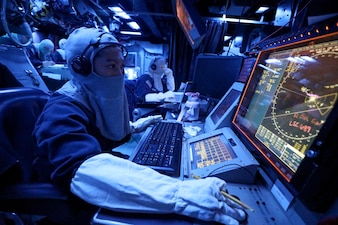 OS1 Ruchel Papa stands watch in the combat information center during a general quarters drill aboard USS Dewey (DDG 105) in the Andaman Sea.