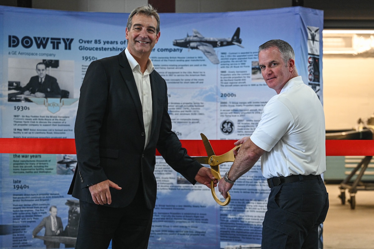 Kerry Garfield, senior contract manager, left, and James Farrell, 19th Civil Engineer Squadron fire and emergency services assistant chief, right, pose for a photo at Little Rock Air Force Base, Arkansas, Oct. 10, 2024. Team Little Rock celebrated the unveiling of an addition to building 466 which was constructed to enhance propeller upkeep and maintain optimal conditions for sensitive maintenance procedures.