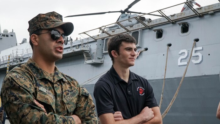 U.S. Marine Corps Cpl. Seth Abeyta, a rifleman with 3rd Light Armored Reconnaissance Battalion, 1st Marine Division, discusses Light Armored Vehicles with a Marine Corps officer candidate during a tour of the amphibious transport dock USS Somerset (LPD 25) during San Francisco Fleet Week 2024 in San Francisco, Oct. 12, 2024. SFFW, now in its 43rd iteration, is a time-honored sea service celebration that allows citizens of the Bay Area to witness today’s maritime capabilities firsthand. Nearly 2,500 Sailors, Marines, and Coast Guardsmen will showcase their capabilities and equipment, participate in various community service events, and enjoy the hospitality of the Bay Area during the event. (U.S. Marine Corps photo by Lance Cpl. Avery Wayland)