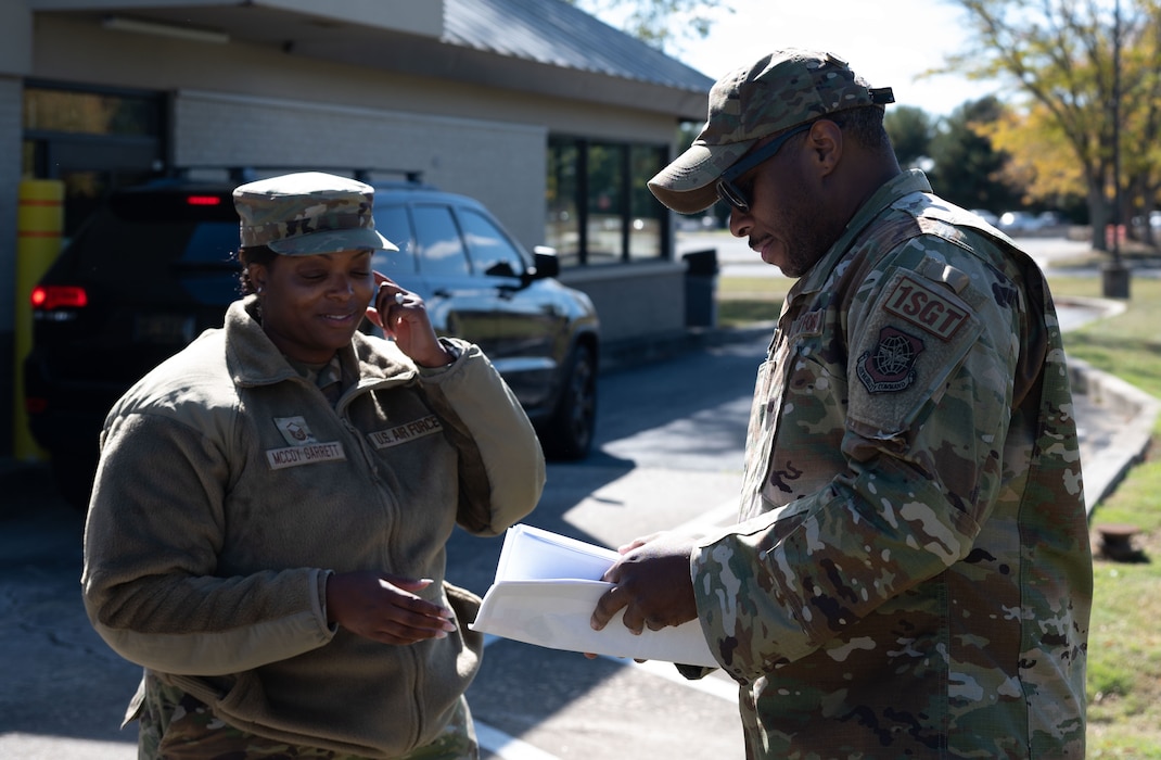 U.S. Air Force Master Sgt. Dwayne Hatchet, right, 436th Aircraft Maintenance Squadron first sergeant, hands papers to Master Sgt. Mercedes McCoy Garrett, 512th Memorial Affairs Squadron first sergeant, at Dover Air Force Base, Delaware, Oct. 16, 2024. The event was facilitated by Team Dover’s first sergeants, Operation Warm Heart is a nonprofit organization that is dedicated to providing emergency financial relief, morale building and quality of life enhancements to military members and their families stationed at Dover AFB. (U.S. Air Force Photo by Senior Airman Dieondiere Jefferies